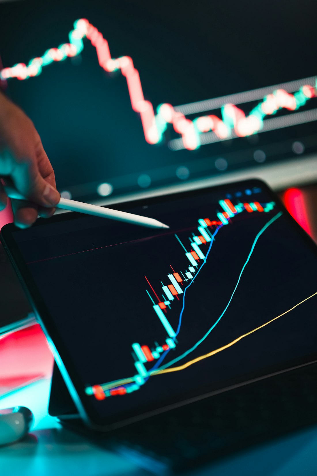 Mão apontando para um gráfico financeiro em uma tela